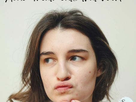 A teenage girl ready to pop a pimple on her chin