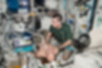 A man performing a ultrasound on another man in a space vehicle