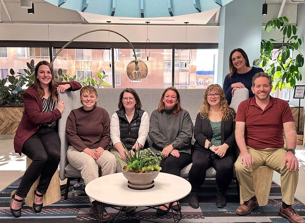 Second Wind Fund team gathers around a couch at the Second Wind Fund office