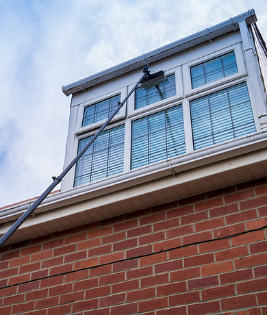 Window cleaner using an extendable easy reach brush to clean a house window within a resid