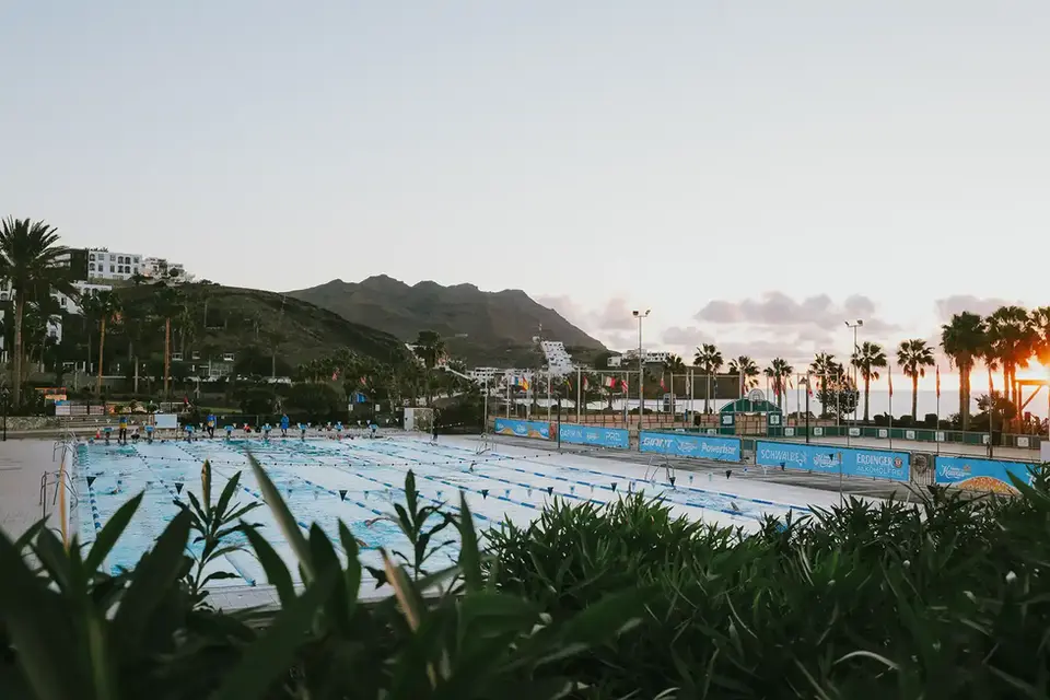 Blick auf den olympischen Pool des Playitas Resort mit Hannes Hawaii Tours, im Hintergrund Berge und Palmen