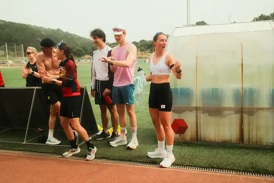 Teilnehmer in Laufkleidung beim 808 Running Camp stehen an der Tartanbahn eine Sportanlage