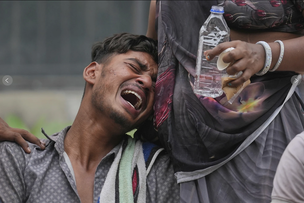 Man in distress leans on woman holding water bottle. Emotional scene outdoors, colorful clothing. Mood: anguished.