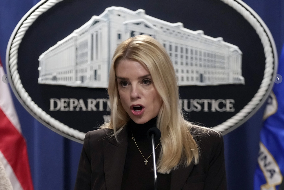 Blonde woman speaking at a podium, Department of Justice seal in the background, serious expression, black jacket, U.S. flag visible.