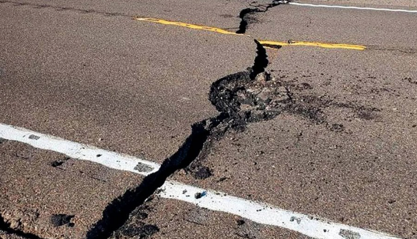 A large crack spans across an asphalt road in Las Vegas, highlighting the significant impact of a recent earthquake.