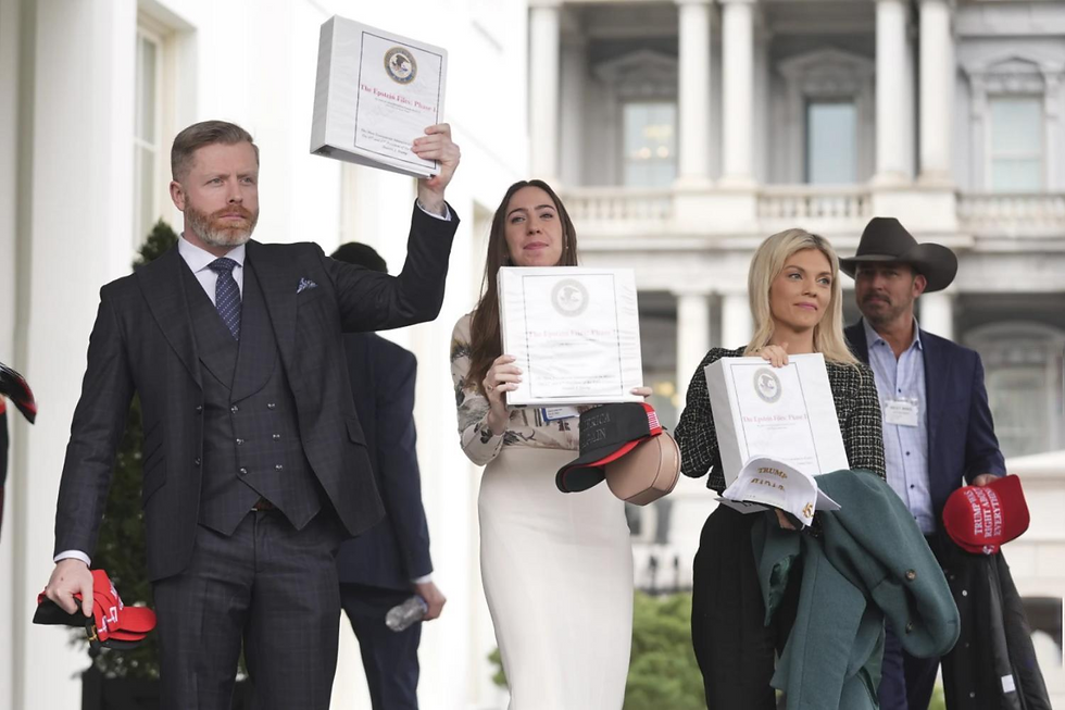 Four people holding binders labeled "The Epstein Files" stand outside a building. They carry hats with "Trump" text, looking serious.