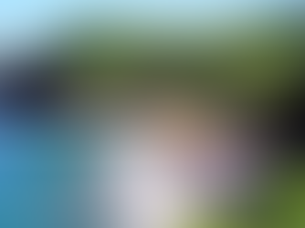 Złocista plaża otoczona zielonymi klifami i sosnami kaledońskimi, z falami Oceanu Spokojnego u wybrzeża Nowej Kaledonii