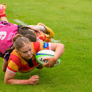 Female rugby players tackling