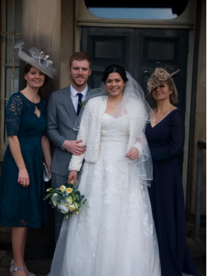 A bride and groom posing with their mothers
