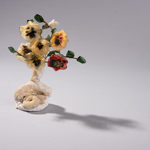 Handmade pansy flowers crafted from fish scales and coral, arranged as a small sculptural bouquet.