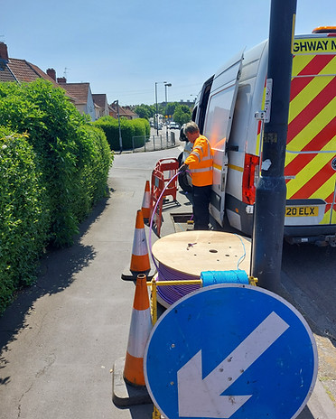 Cabling work be completed on site by an engineer near a work van.