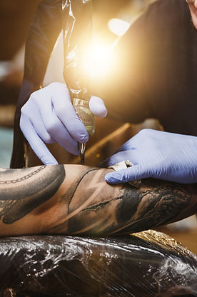 Neil Rubio tattooing a sleeve of a skull in black and grey