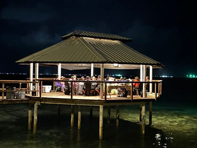 Guests sharing an evening meal in the overwater gazebo at Bokanbotin Island Resort, Marshall Islands