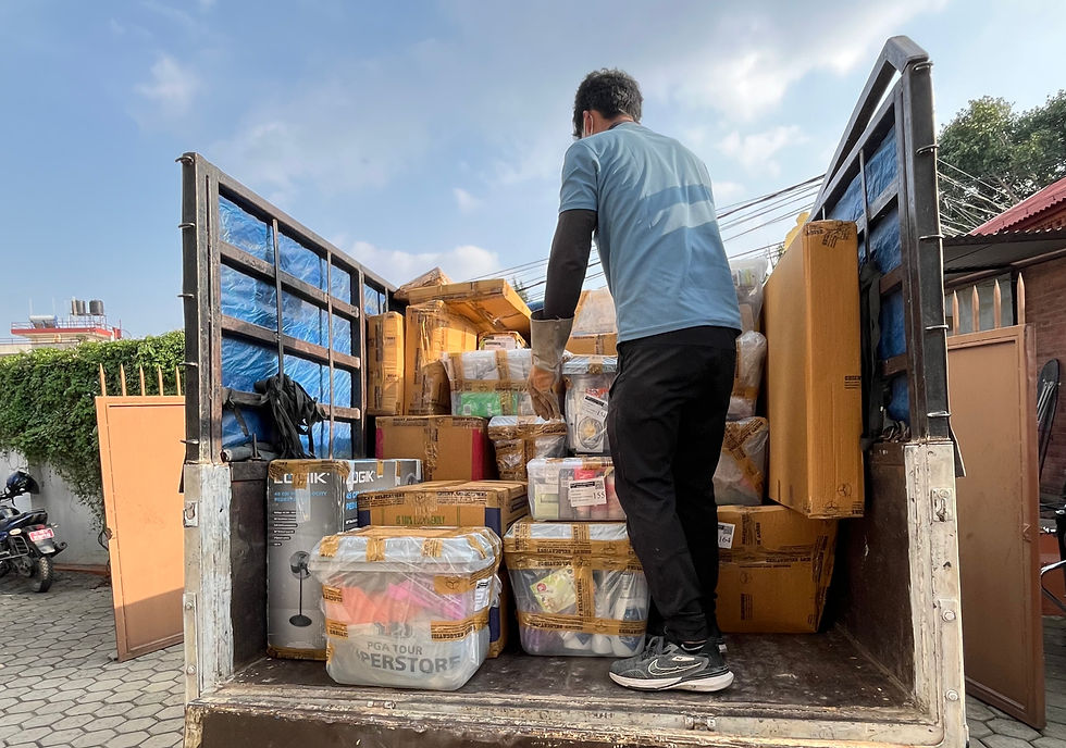 An Orient Relocation worker meticulously organizes packed household goods onto a truck in Kathmandu, preparing them for transport.