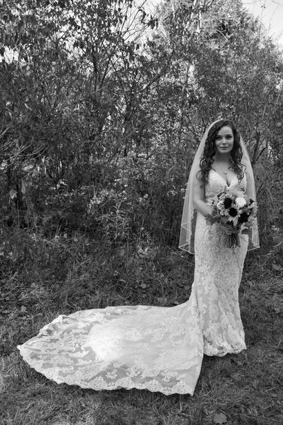 Bride taking pictures on outdoor walking trail