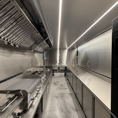 Interior de cocina comercial de acero inoxidable, limpia, moderna y equipada.