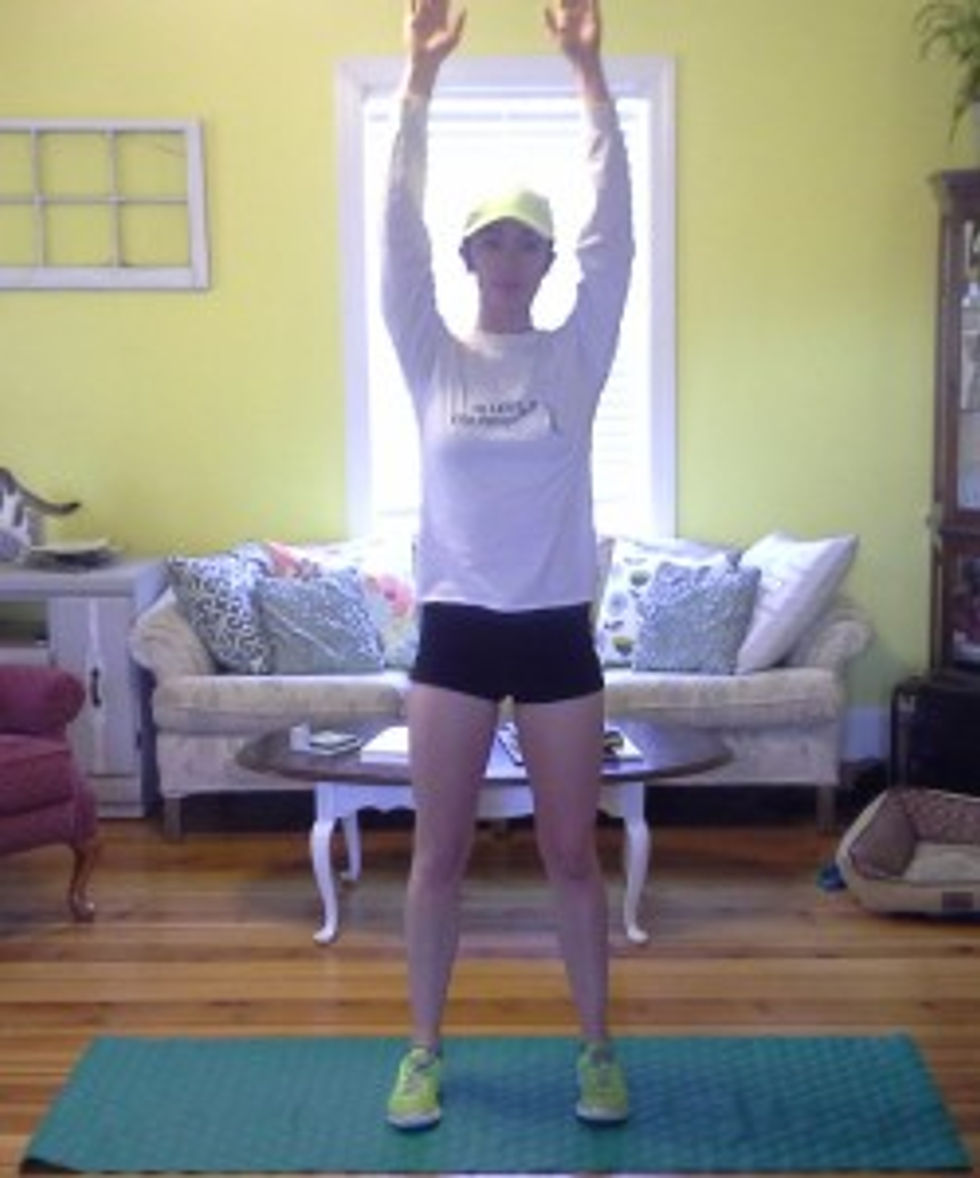 Stand tall with your feet about hip width apart. Raise your arms above your head without shrugging so your neck stays relaxed.
