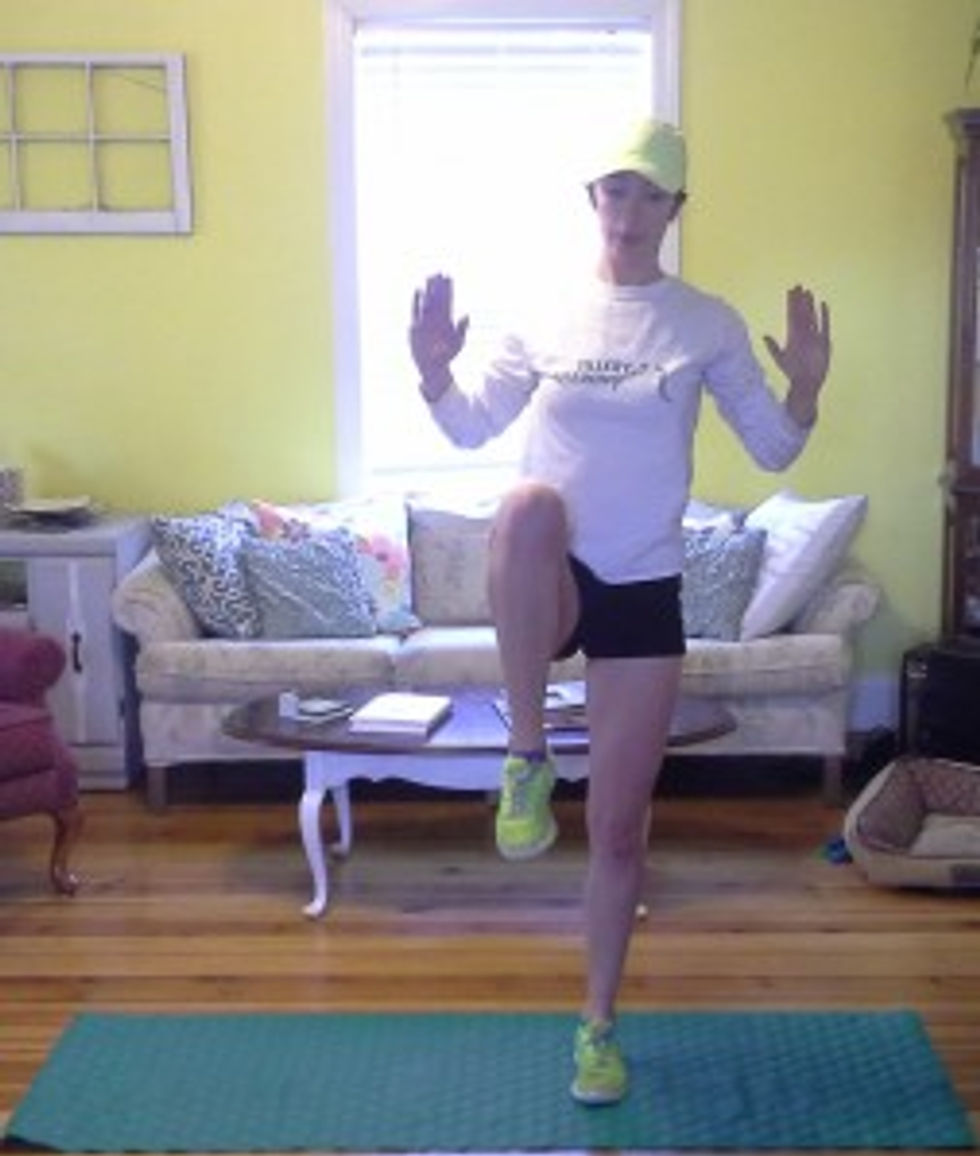 Stand up powerfully and, as you do, draw one knee up to your chest as you pull your elbows down toward your hips. Think about compressing your core, but maintain a tall posture.