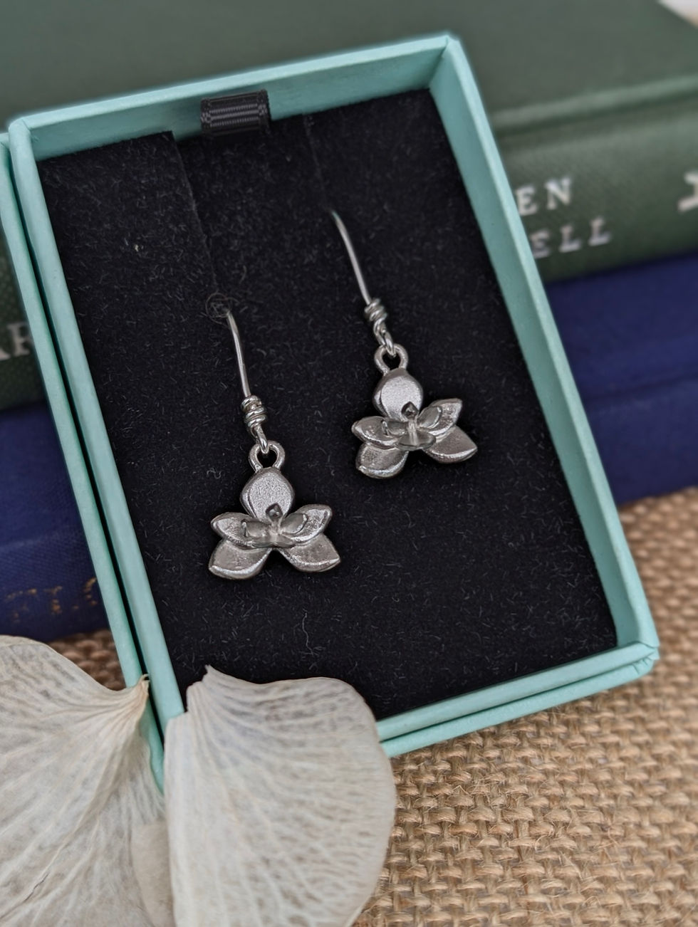 Thumbnail: silver orchid drop earrings displayed in a giftbox