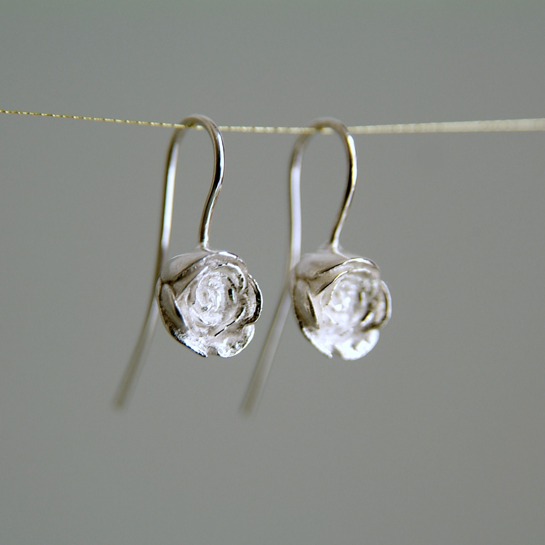 silver rose bud drop earrings by rock rose jewellery