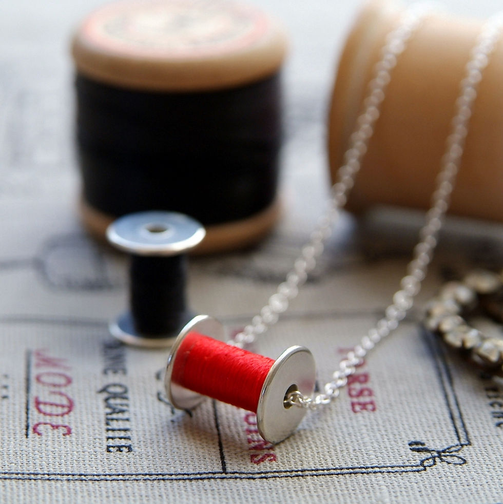 Thumbnail: Red Bobbin and Black Bobbin Necklaces on a Sewing Display