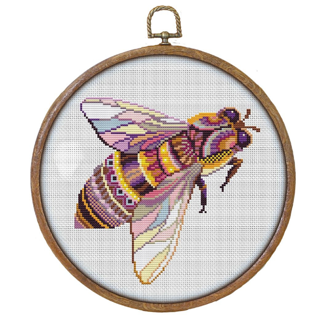 Mandala bee counted cross stitch design shown complete in a faux wooden hoop with purples and yesllows