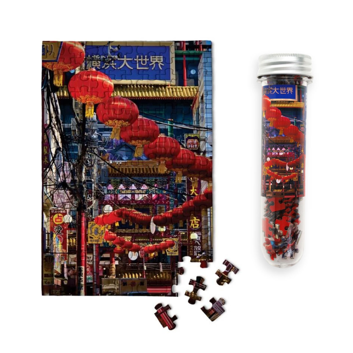 tube of micro mini 150 piece puzzle of chinese lanterns in japan next to a nearly completed jigsaw puzzle