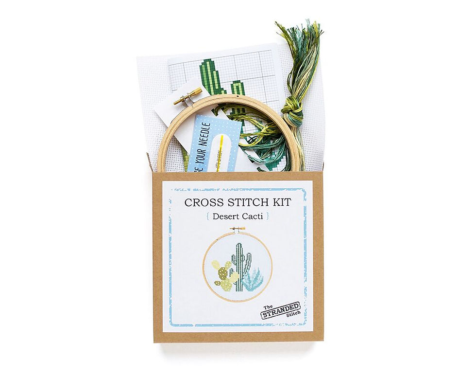 Thumbnail: contents of desert cacti cross stitch kit coming out of the box including 5 inch wood embroidery hoop, aida, needle, floss