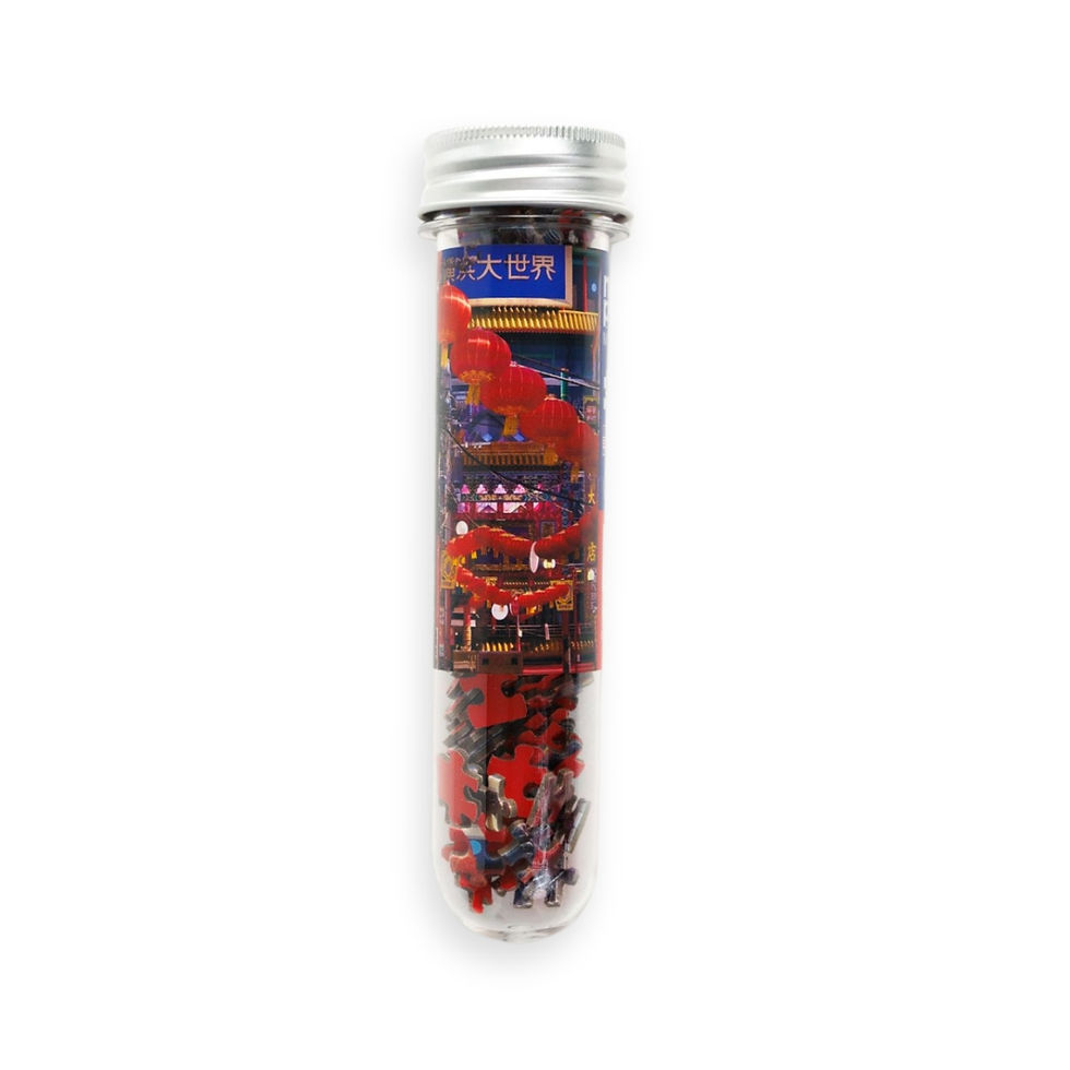 clear tube of micro puzzle with label of jigsaw image of chinese lanterns in japan. Mini puzzle pieces are seen at tube base