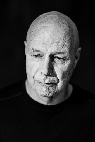 A photo of the Actor/Writer Sean Casey Leclaire. Black and white, he is looking down and has a thoughtful, serene expression on his face.