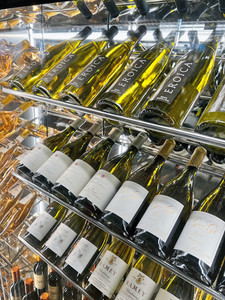 A Wine Fridge at Topolino's Terrace, with many bottles of white wine displayed. This fridge is in the waiting area of Disney's Riviera Resort at Walt Disney World.