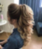 High ponytail with voluminous, cascading waves