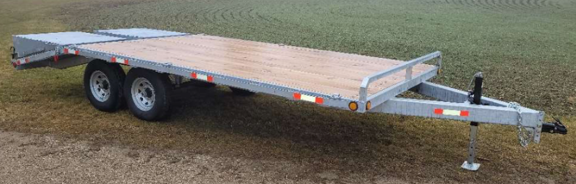 Deckover trailer with fold-over ramps lowered for equipment loading