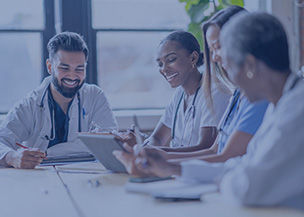 4 people laughing at a conference table