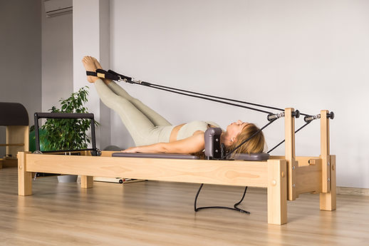 Woman training pilates on the reformer bed Reformer pilates studio machine for fitness wor