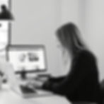 black and white photo of a woman with light hair designing a web prototype on laptop or co