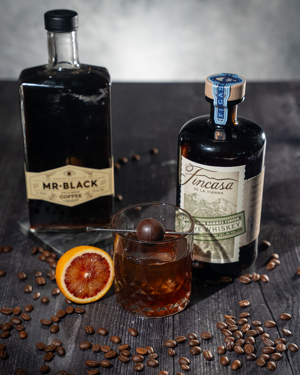 Una botella de Fincasa Whiskey, una botella de Mr. Black coffee liquor y un old fashioned de café.