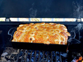 focaccia cocinándose sobre carbón en la parrilla tradicional de carbon de Chargriller