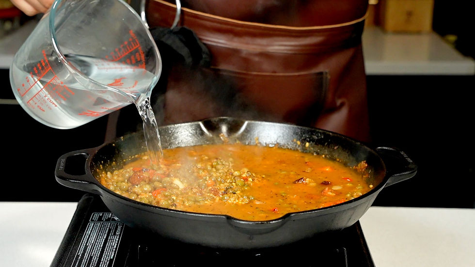 mano agregando agua al asopao de gandules de Criollo Grindz