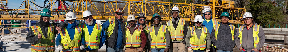 Construction team in safety vests and hard hats on site