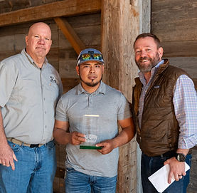 2025 winners posing with an award in a rustic barn setting