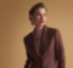 Elegant brown women’s pantsuit with blazer, posed in a minimalist studio Ideal for fashion