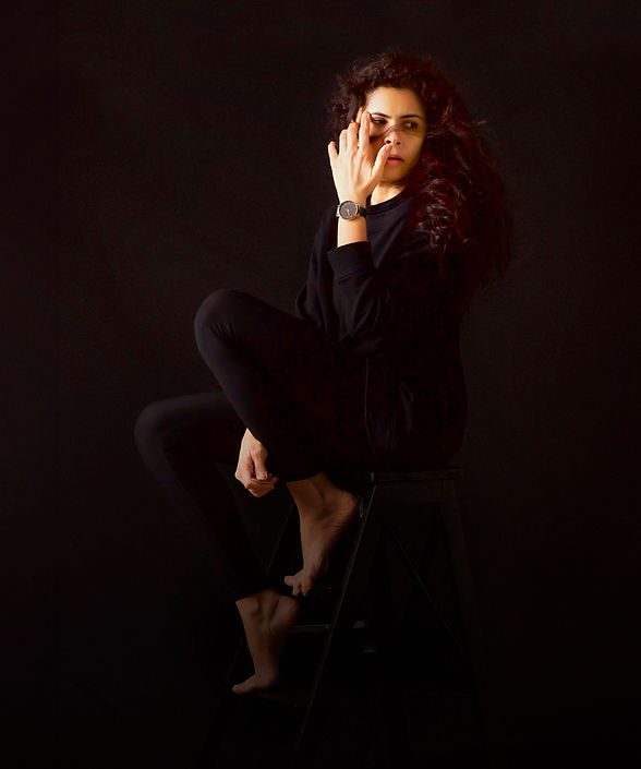 Self portrait of the women and family photographer behind Portrait by Taru Studio where she is wearing a black outfit and sitting on a vintage ladder while looking back and her red hair is blowing in the wind making her feel truly beautiful and empowered in Plymouth Minneapolis Minnesota MN Midwest.
