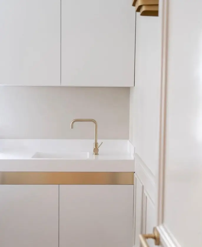 Minimalist white salon sink with gold hardware