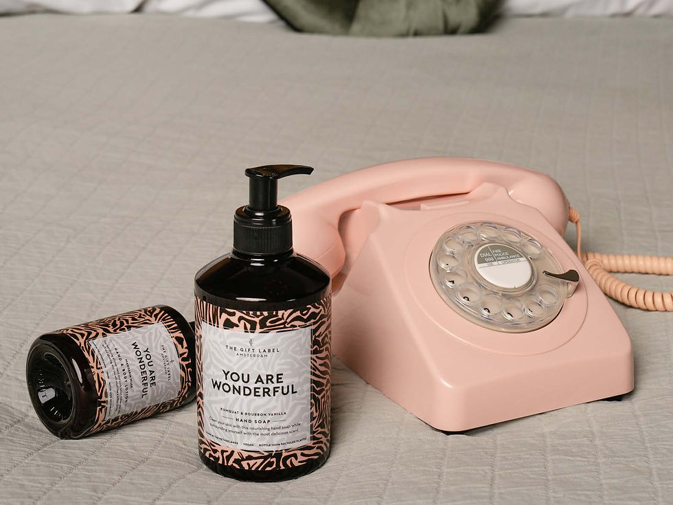 The Gift Label, Körperpflegeprodukte, hier eine Bodylotion und ein Gel, neben einem pinken Telefon.