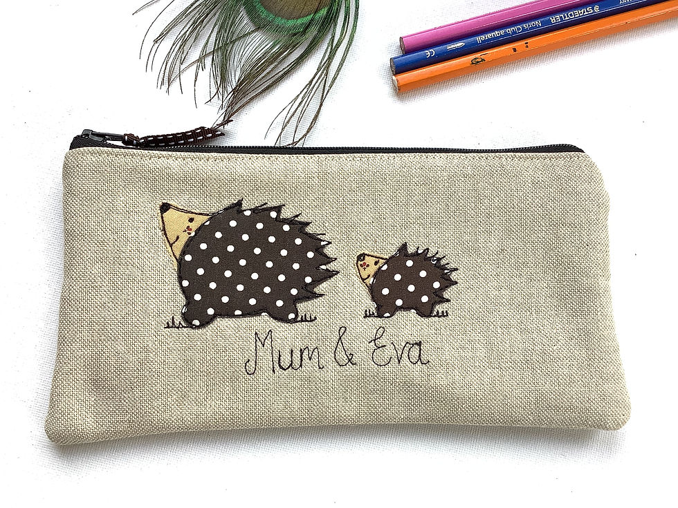 Thumbnail: Hedgehog motif applique on linen pencil case or cosmetic bag.  Chocolate dot lining and fastened with zip and ribbon pull