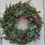 Miniatura: Classic Christmas wreath with red berries, evergreen, and seasonal decorations. La Magia Del Natale.