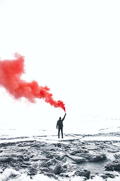 A person holding a flare with red smoke: better find, see and use info on violent extremism.