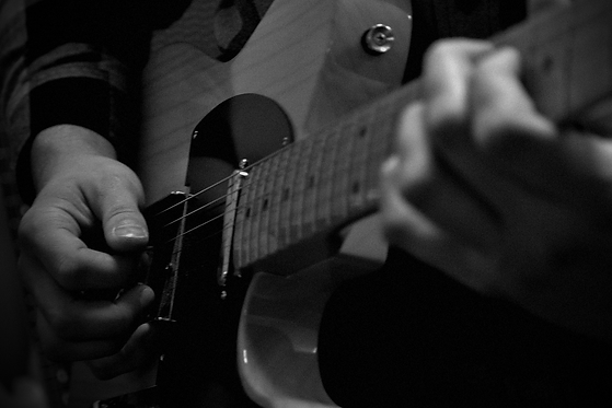 Guitar teacher strumming an electric guitar