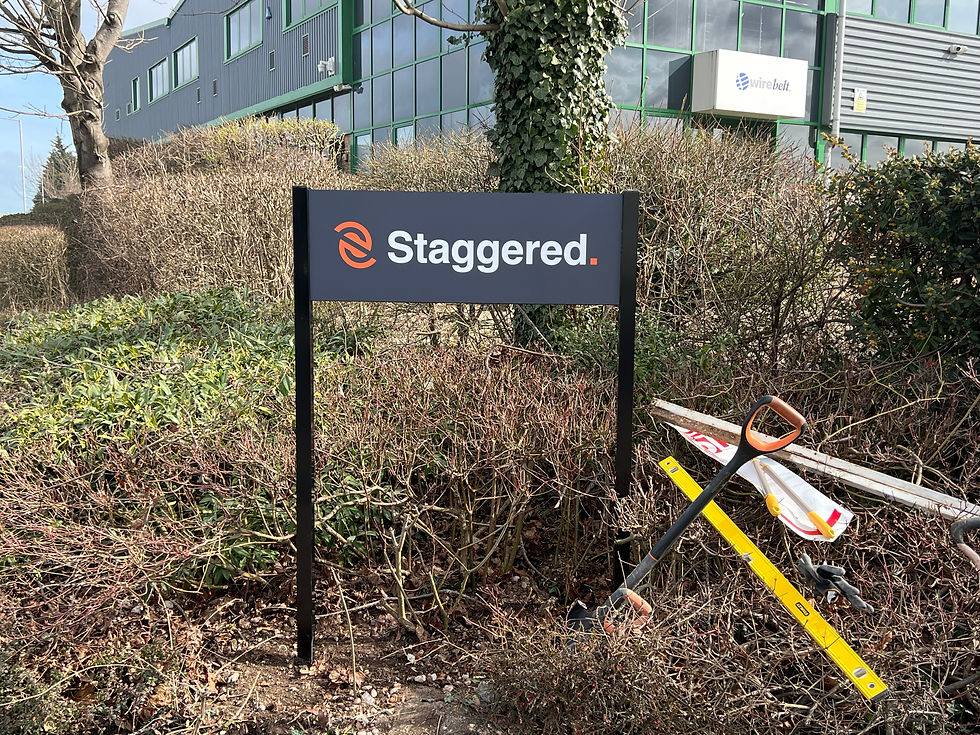 New Staggered post and panel sign with dark grey branded panel and black posts, designed, manufactured and installed by Purple Frog Signs outside commercial premises.
